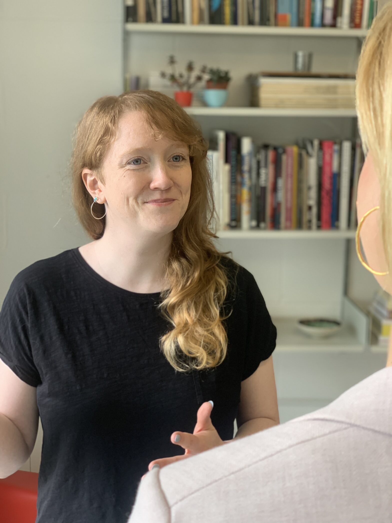 Julia and Eleanor, two charity agile coaches, standing up having a conversation.